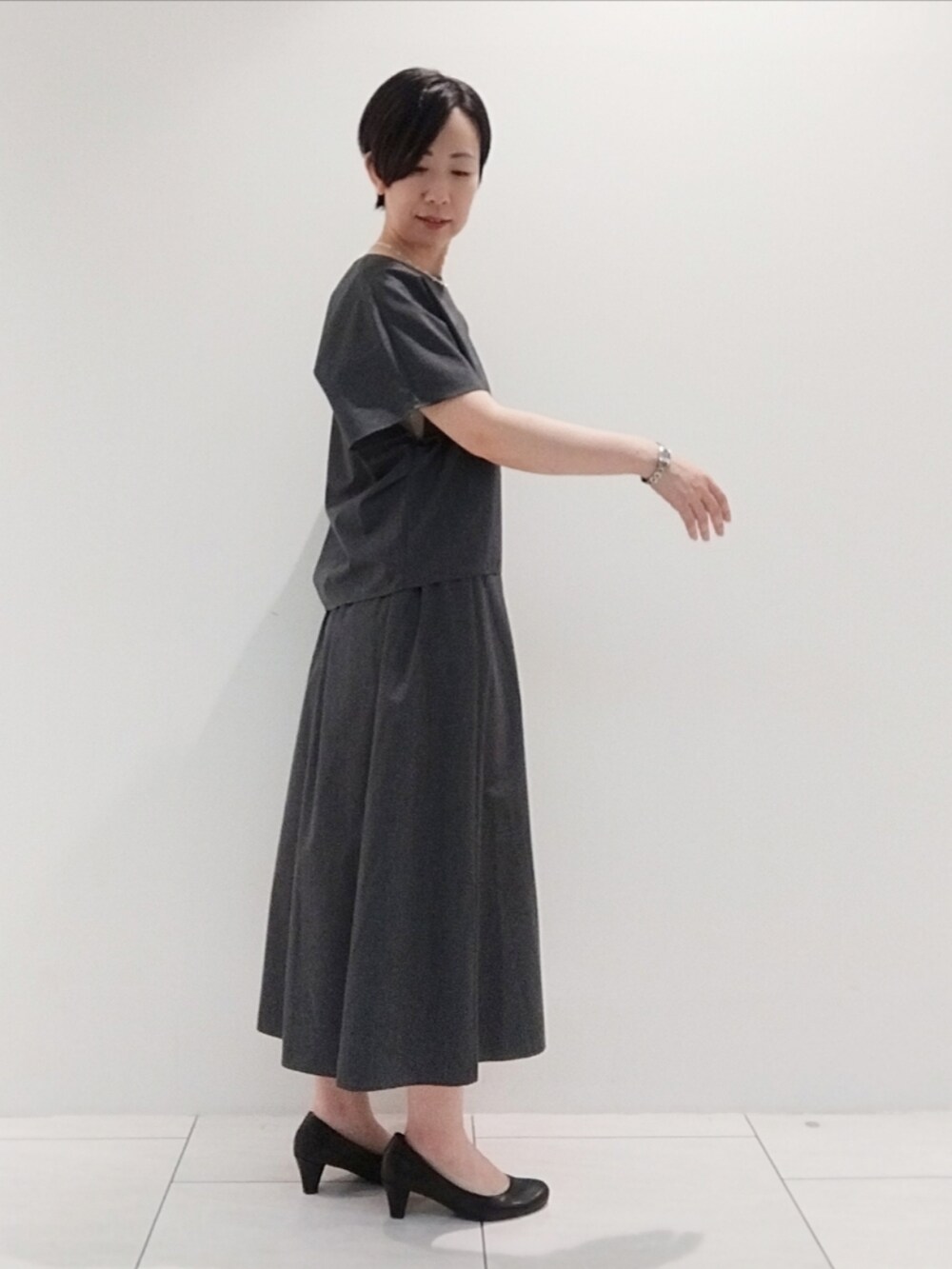 グレー系のシャツ/ブラウス、グレー系のスカート、シルバー系のネックレスを着用したレディースの夏コーディネートの4枚目の写真