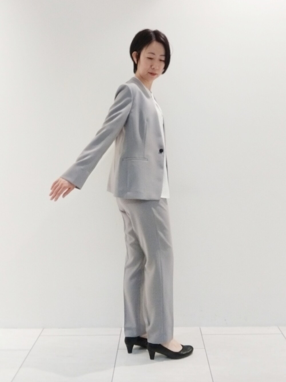 ホワイト系のシャツ/ブラウス、グレー系のスーツジャケット、グレー系のスーツパンツを着用したレディースの春コーディネートの4枚目の写真