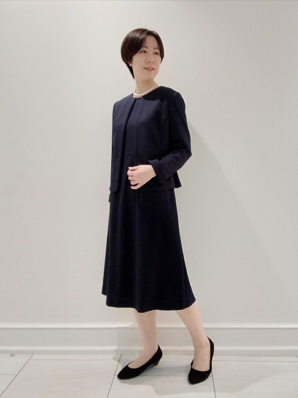 ブラック系のスーツジャケット、ブルー系のワンピース、その他のその他を着用したレディースの秋コーディネートの2枚目の写真