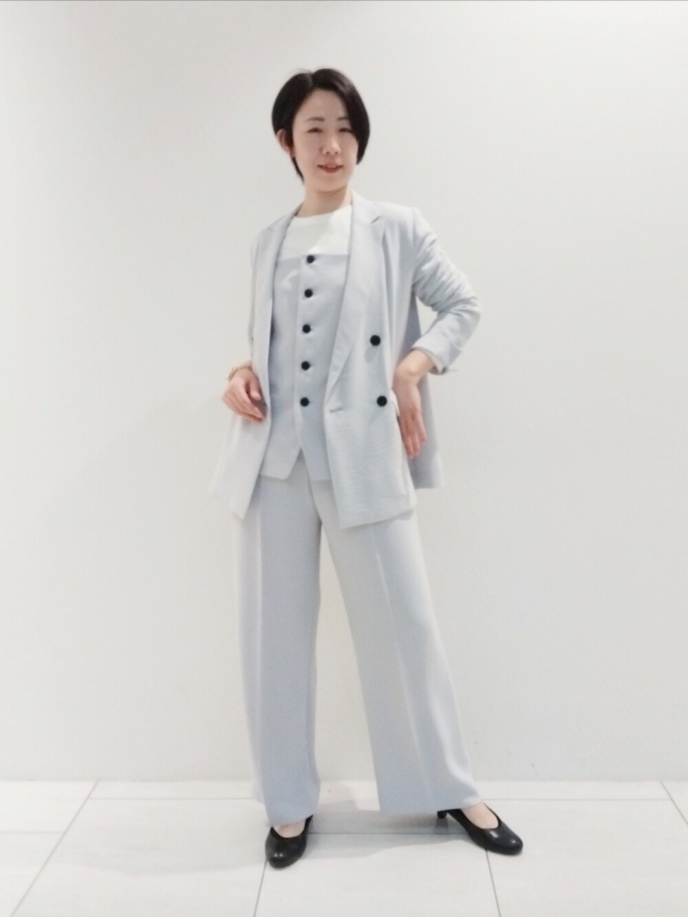 ホワイト系のTシャツ/カットソー、グレー系のタンクトップ、グレー系のスーツジャケットを着用したレディースの春コーディネートの2枚目の写真