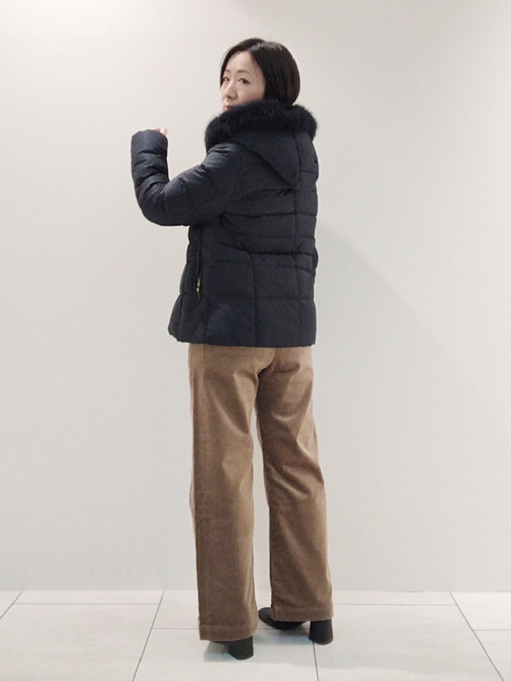 ブルー系のダウンジャケット/コート、ホワイト系のニット/セーター、ベージュ系のその他パンツを着用したレディースの冬コーディネートの5枚目の写真