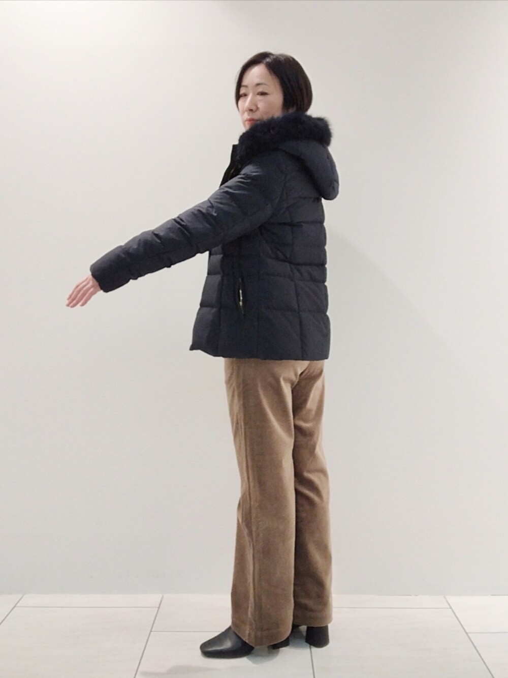 ブルー系のダウンジャケット/コート、ホワイト系のニット/セーター、ベージュ系のその他パンツを着用したレディースの冬コーディネートの4枚目の写真