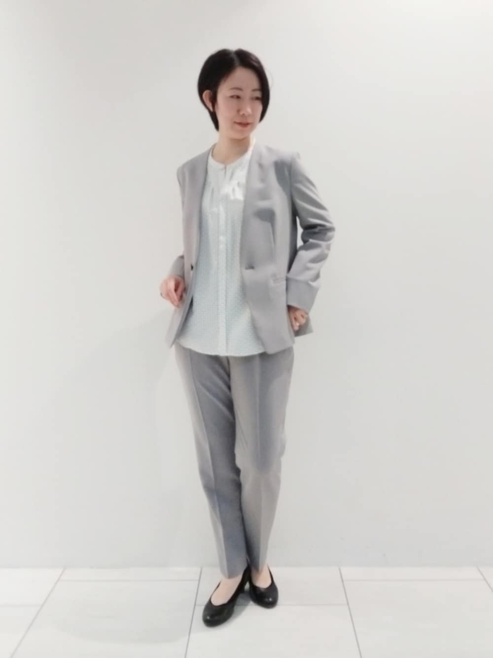 ホワイト系のシャツ/ブラウス、グレー系のスーツジャケット、グレー系のスーツパンツを着用したレディースの春コーディネートの2枚目の写真