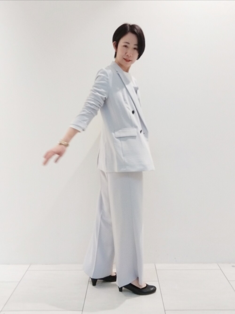 ホワイト系のTシャツ/カットソー、グレー系のタンクトップ、グレー系のスーツジャケットを着用したレディースの春コーディネートの4枚目の写真