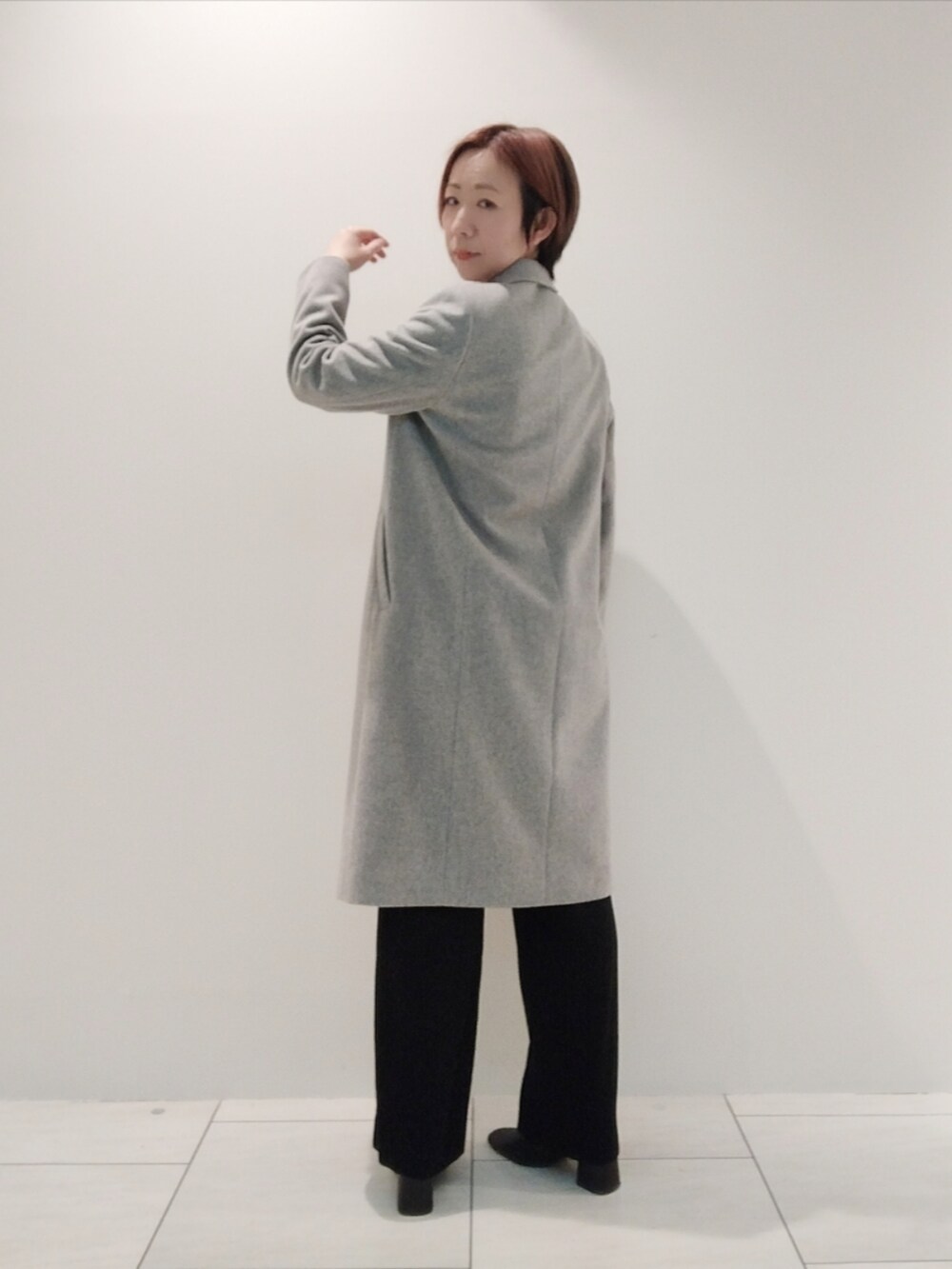 グレー系のチェスターコート、ブラック系のシャツ/ブラウス、ブラック系のスーツパンツを着用したレディースの冬コーディネートの5枚目の写真