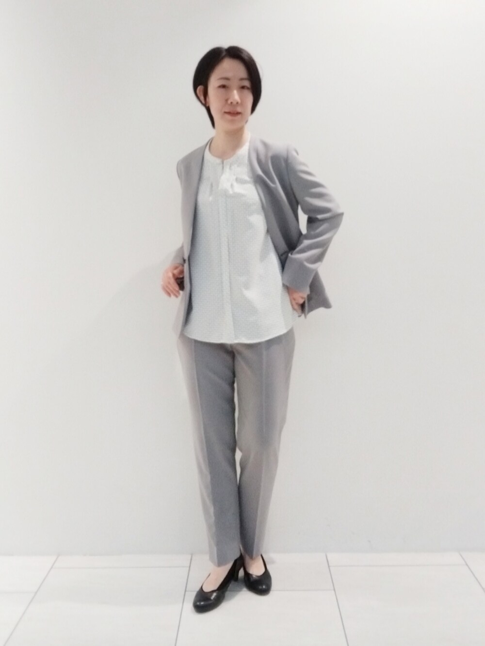 ホワイト系のシャツ/ブラウス、グレー系のスーツジャケット、グレー系のスーツパンツを着用したレディースの春コーディネートの3枚目の写真