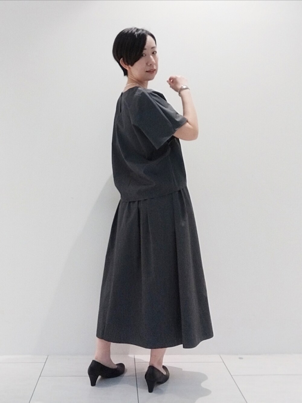 グレー系のシャツ/ブラウス、グレー系のスカート、シルバー系のネックレスを着用したレディースの夏コーディネートの5枚目の写真