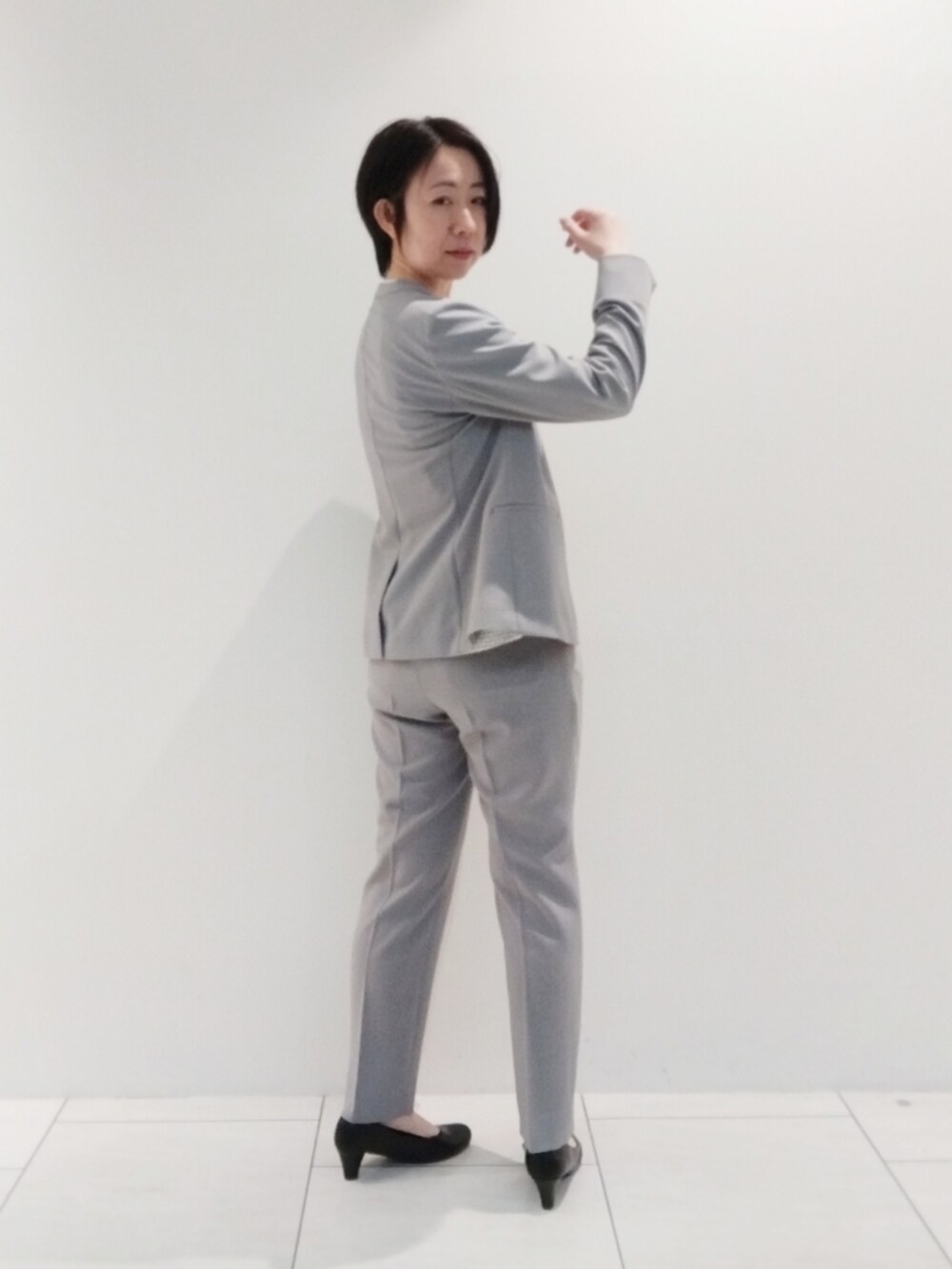 ホワイト系のシャツ/ブラウス、グレー系のスーツジャケット、グレー系のスーツパンツを着用したレディースの春コーディネートの5枚目の写真