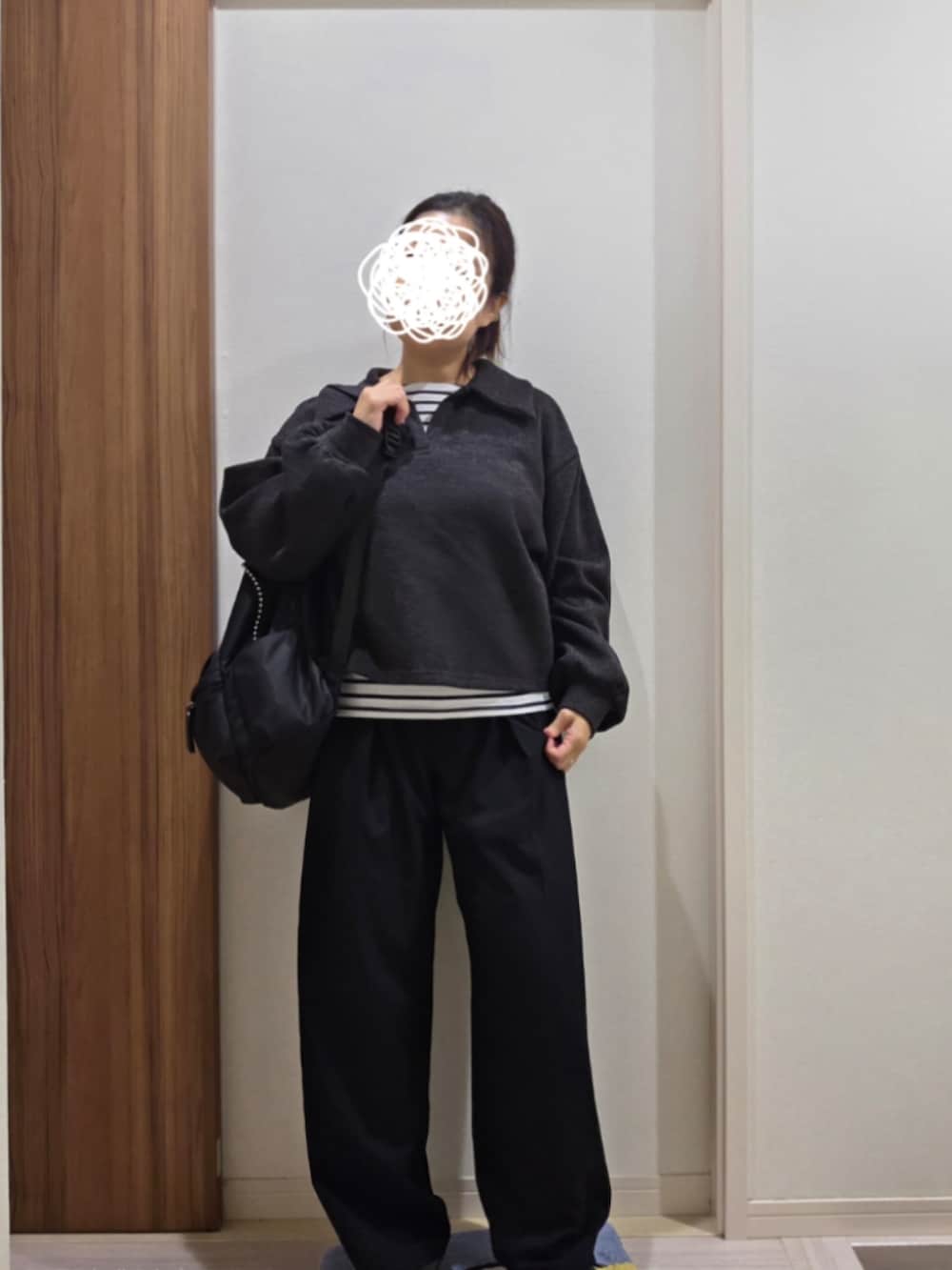 ブラック系のスラックス、グレー系のニット/セーターを着用したレディースの秋コーディネートの2枚目の写真