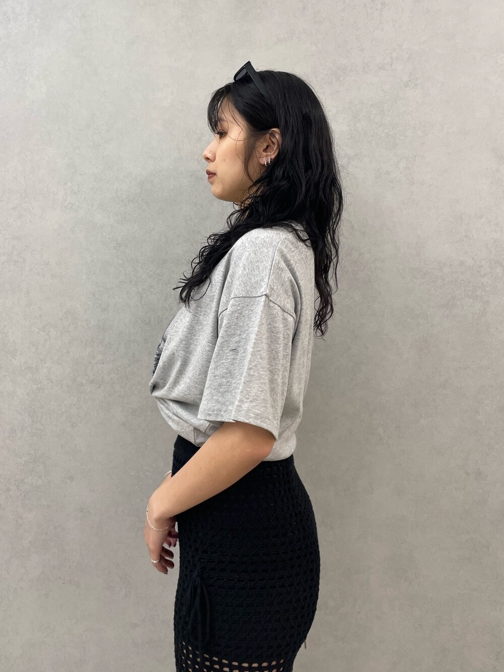 グレー系のTシャツ/カットソー、ブラック系のスカート、ブラック系のサンダルを着用したレディースの春コーディネートの5枚目の写真