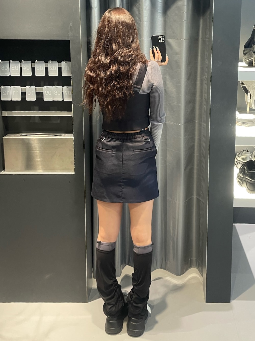 グレー系のニット/セーター、ブルー系のスカート、シルバー系のスニーカーを着用したレディースの冬コーディネートの3枚目の写真