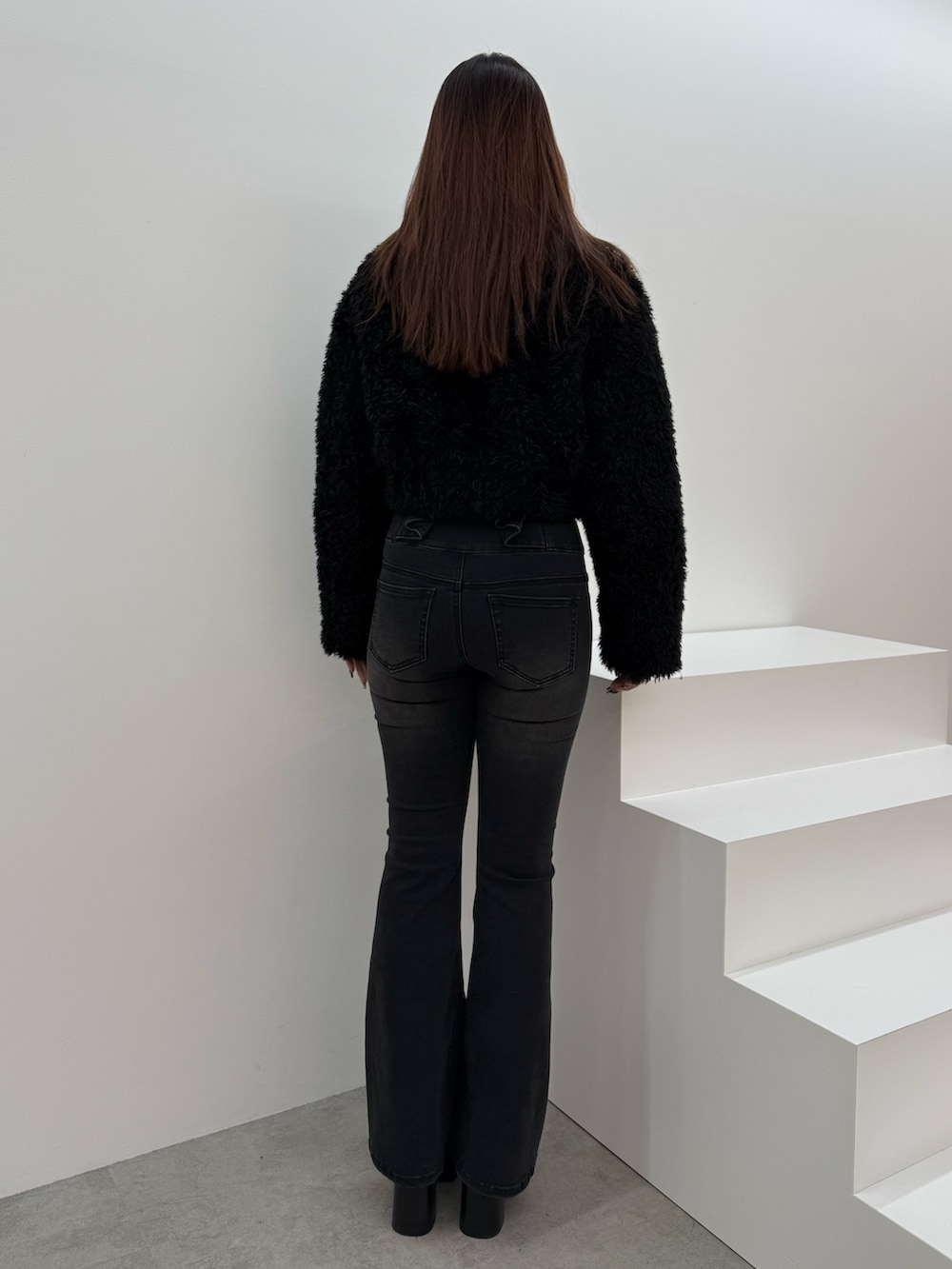 ブラック系のブルゾン、ブラック系のデニムパンツ、ブラック系のブーツを着用したレディースの冬コーディネートの3枚目の写真