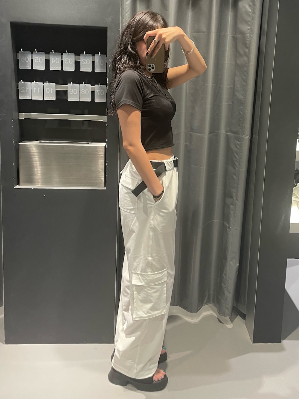 ブラック系のTシャツ/カットソー、ホワイト系のカーゴパンツ、ブラック系のサンダルを着用したレディースの夏コーディネートの2枚目の写真