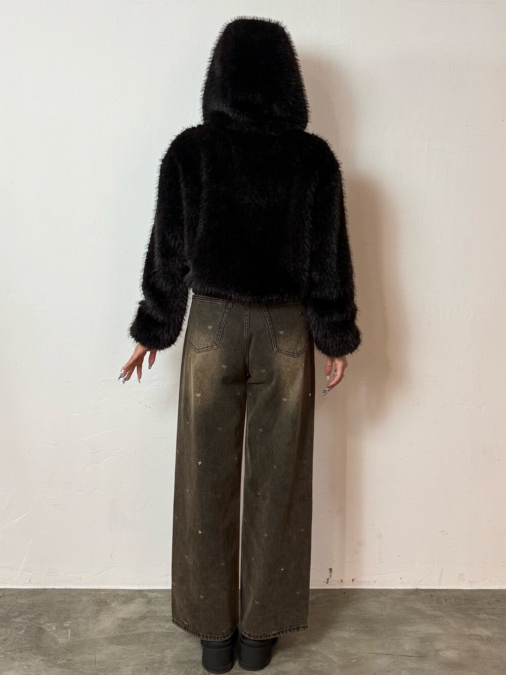 ブラック系のブルゾン、ブラウン系のデニムパンツ、ブラック系のブーツを着用したレディースの秋コーディネートの3枚目の写真