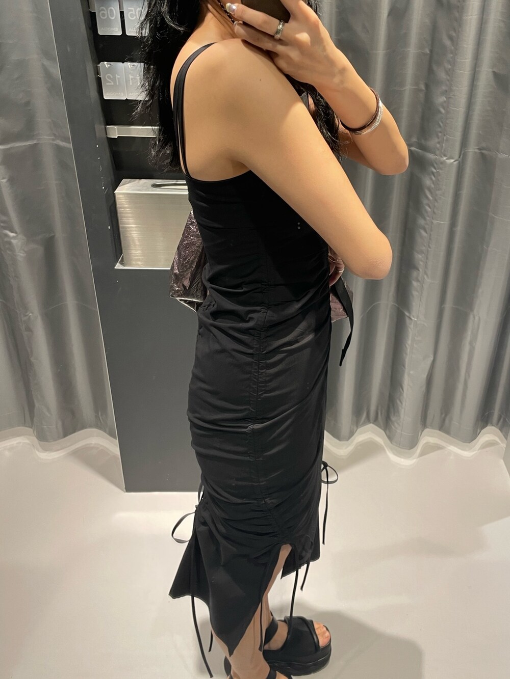 ブラック系のワンピース、グレー系のハンドバッグ、ブラック系のサンダルを着用したレディースの春コーディネートの7枚目の写真