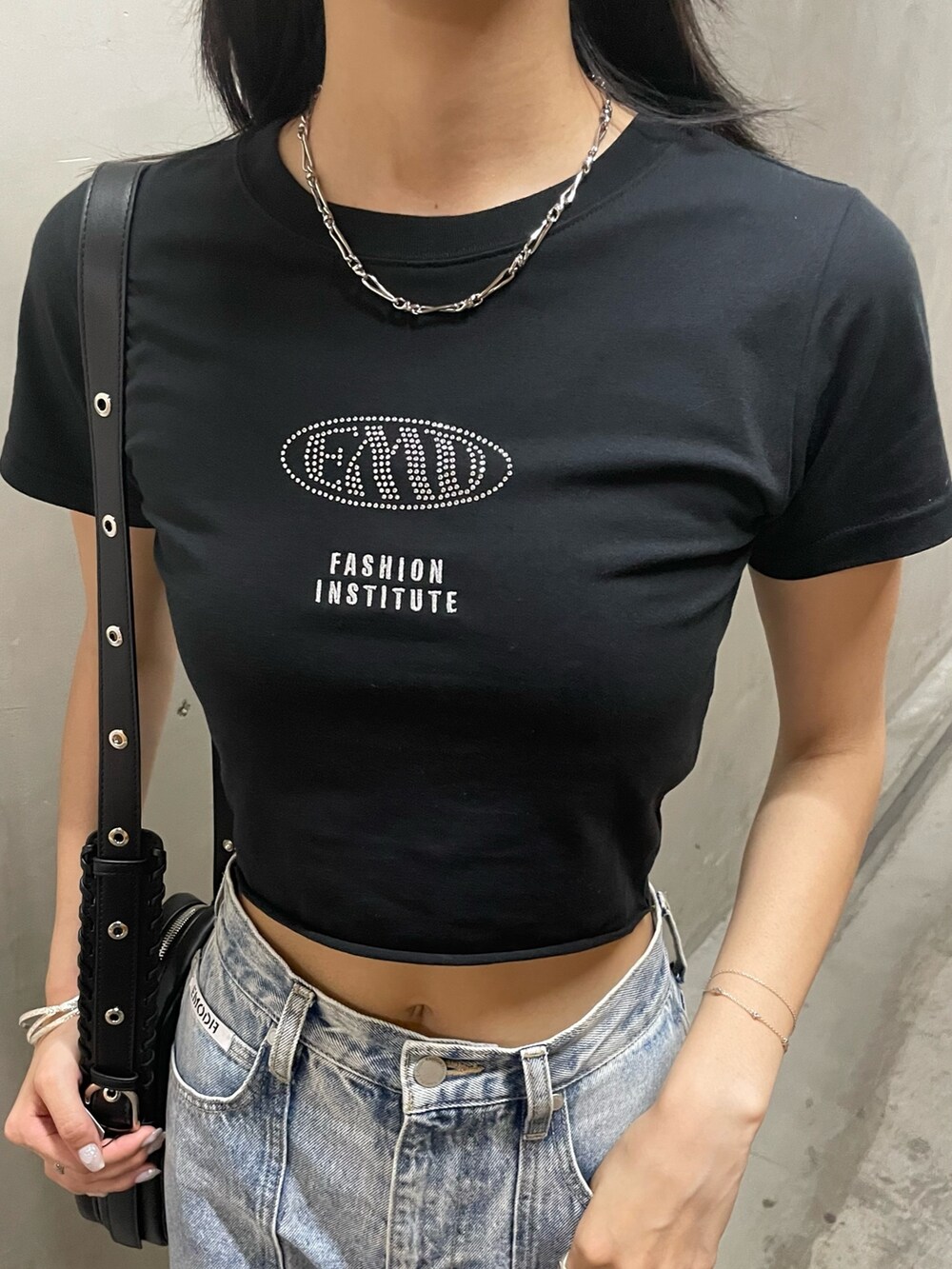 ブラック系のTシャツ/カットソー、ブラック系のショルダーバッグ、ブルー系のデニムパンツを着用したレディースの夏コーディネートの3枚目の写真