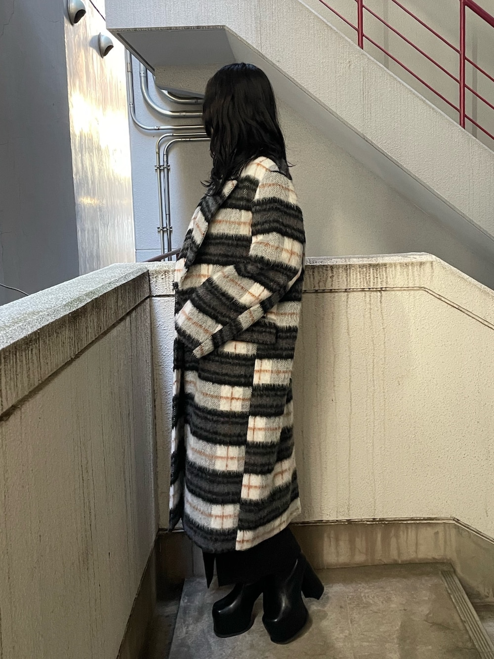 グレー系のニット/セーター、その他のチェスターコート、ブラック系のスカートを着用したレディースの冬コーディネートの2枚目の写真