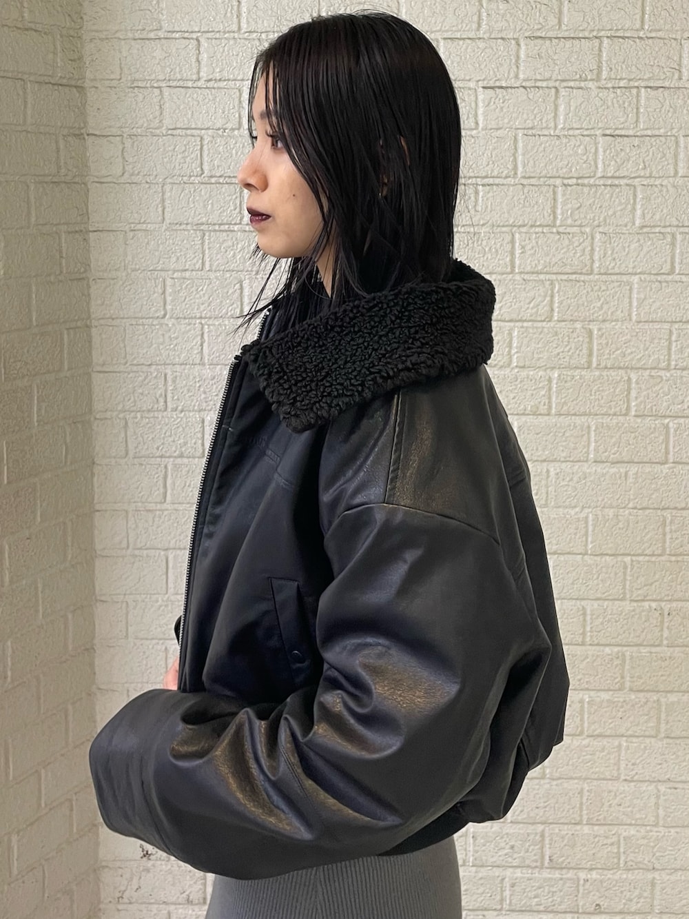 ブラック系のブルゾン、グレー系のワンピース、ブラック系のブーツを着用したレディースの秋コーディネートの5枚目の写真