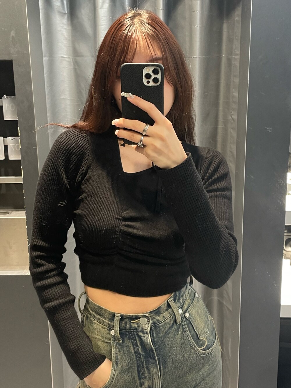 ブラック系のニット/セーター、ブルー系のデニムパンツ、ブラック系のブーツを着用したレディースの冬コーディネートの4枚目の写真