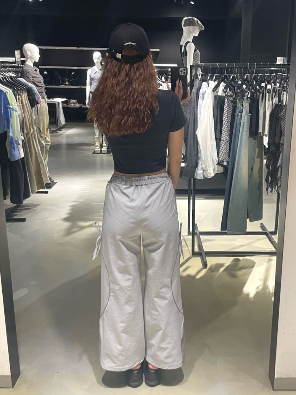 ブラック系のTシャツ/カットソー、グレー系のその他パンツ、ブラック系のサンダルを着用したレディースの春コーディネートの3枚目の写真