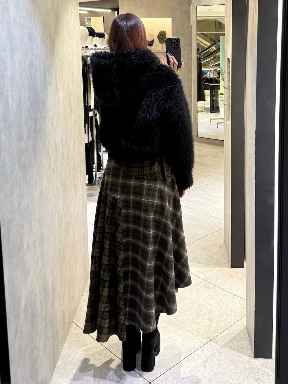 ブラック系のブルゾン、グリーン系のスカート、ブラック系のブーツを着用したレディースの秋コーディネートの3枚目の写真