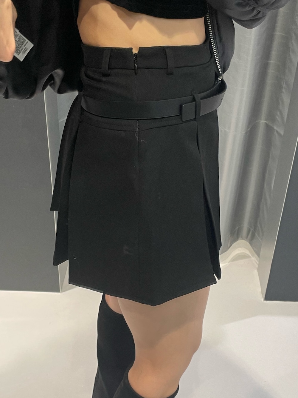 グレー系のニット/セーター、ブラック系のスカート、ブラック系のブーツを着用したレディースの秋コーディネートの7枚目の写真