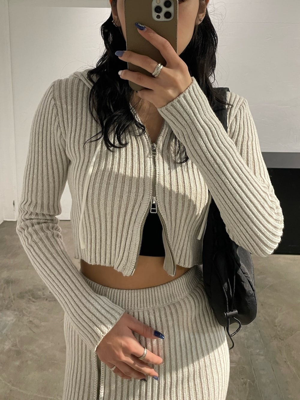 ホワイト系のワンピース、ブラック系のキャミソール、ブラック系のブーツを着用したレディースの春コーディネートの3枚目の写真