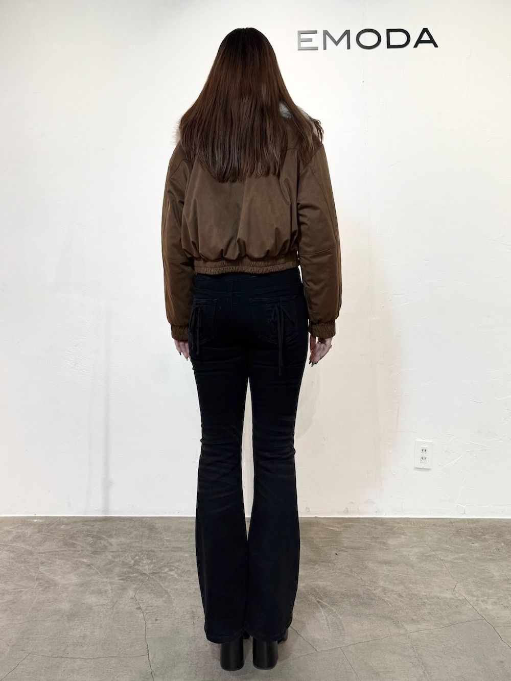 ホワイト系のニット/セーター、ベージュ系のブルゾン、ブラック系のデニムパンツを着用したレディースの冬コーディネートの3枚目の写真