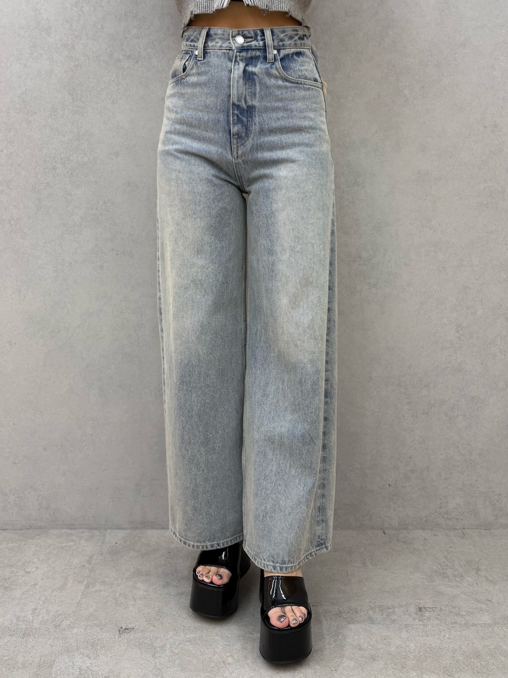 グレー系のニット/セーター、ブルー系のデニムパンツ、ブラック系のサンダルを着用したレディースの春コーディネートの5枚目の写真