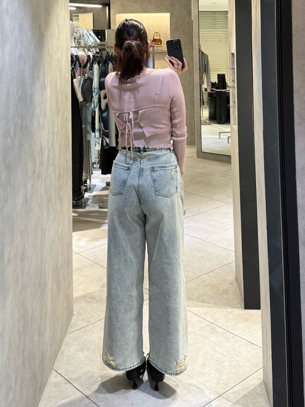 ブルー系のデニムパンツ、ブラック系のスニーカー、ピンク系のニット/セーターを着用したレディースの春コーディネートの3枚目の写真