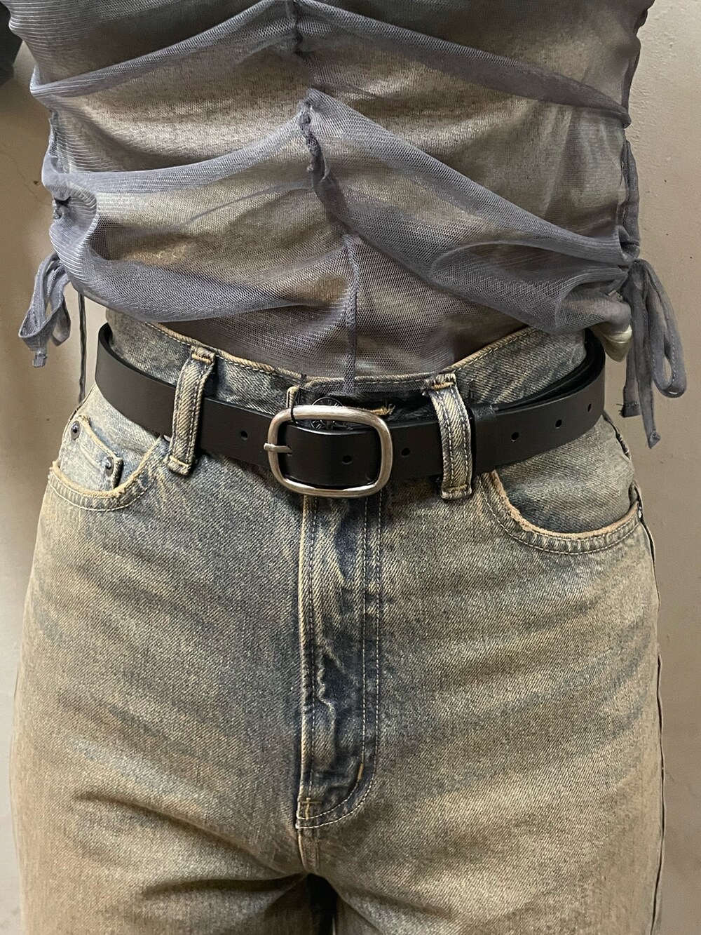 グレー系のTシャツ/カットソー、ブルー系のデニムパンツ、ブラック系のブーツを着用したレディースの春コーディネートの6枚目の写真