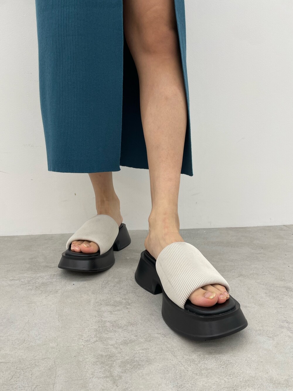 ブルー系のワンピース、ホワイト系のニット/セーター、ホワイト系のサンダルを着用したレディースの春コーディネートの7枚目の写真
