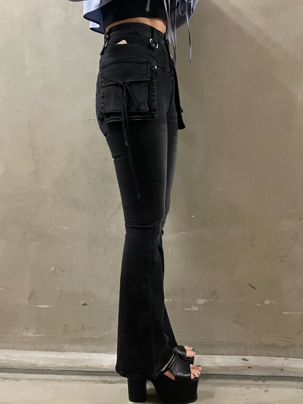 グリーン系のニット/セーター、ブラック系のデニムパンツ、ブラック系のサンダルを着用したレディースの春コーディネートの8枚目の写真