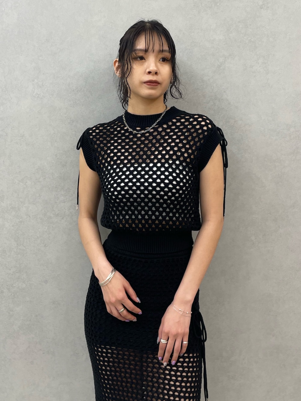 ホワイト系のキャミソール、ブラック系のタンクトップ、ブラック系のスカートを着用したレディースの春コーディネートの4枚目の写真