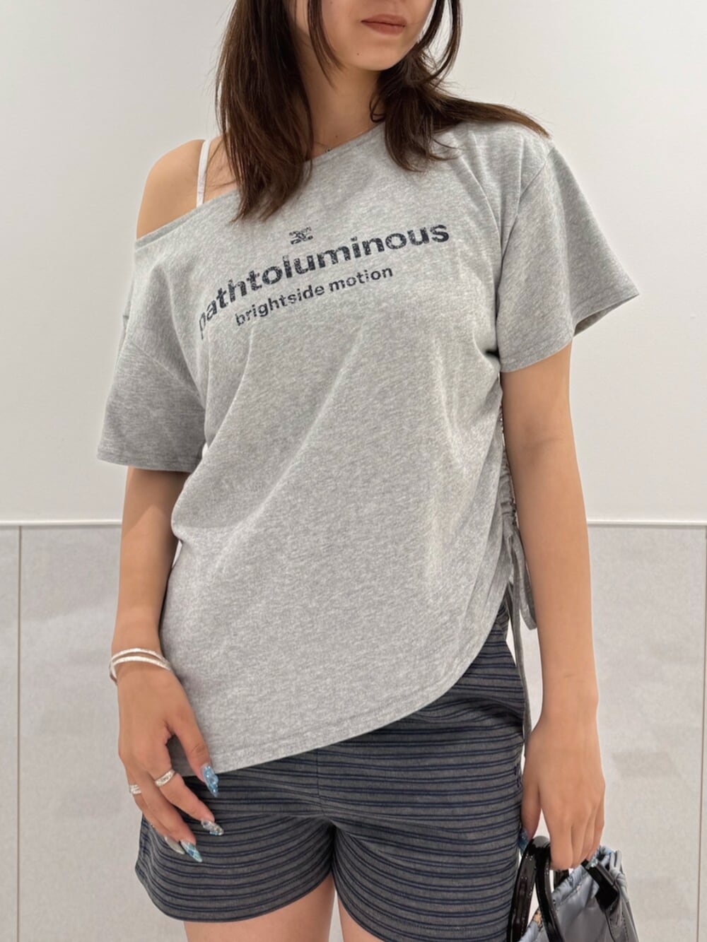 グレー系のTシャツ/カットソー、ブラック系のサンダル、ブラック系のハンドバッグを着用したレディースの夏コーディネートの4枚目の写真