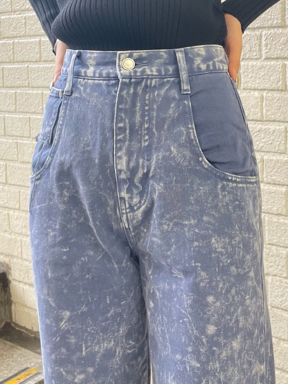 ブラック系のニット/セーター、パープル系のデニムパンツ、ブラック系のブーツを着用したレディースの秋コーディネートの7枚目の写真