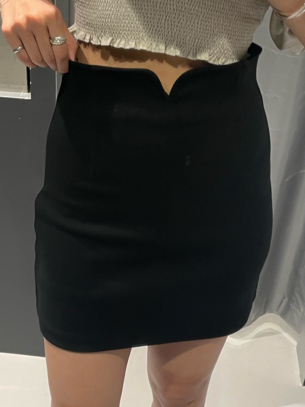 ブルー系のTシャツ/カットソー、ブラック系のスカート、シルバー系のハンドバッグを着用したレディースの夏コーディネートの6枚目の写真