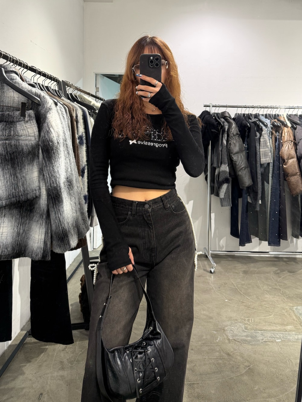 ブラック系のTシャツ/カットソー、ブラック系のデニムパンツ、ブラック系のショルダーバッグを着用したレディースの秋コーディネートの4枚目の写真