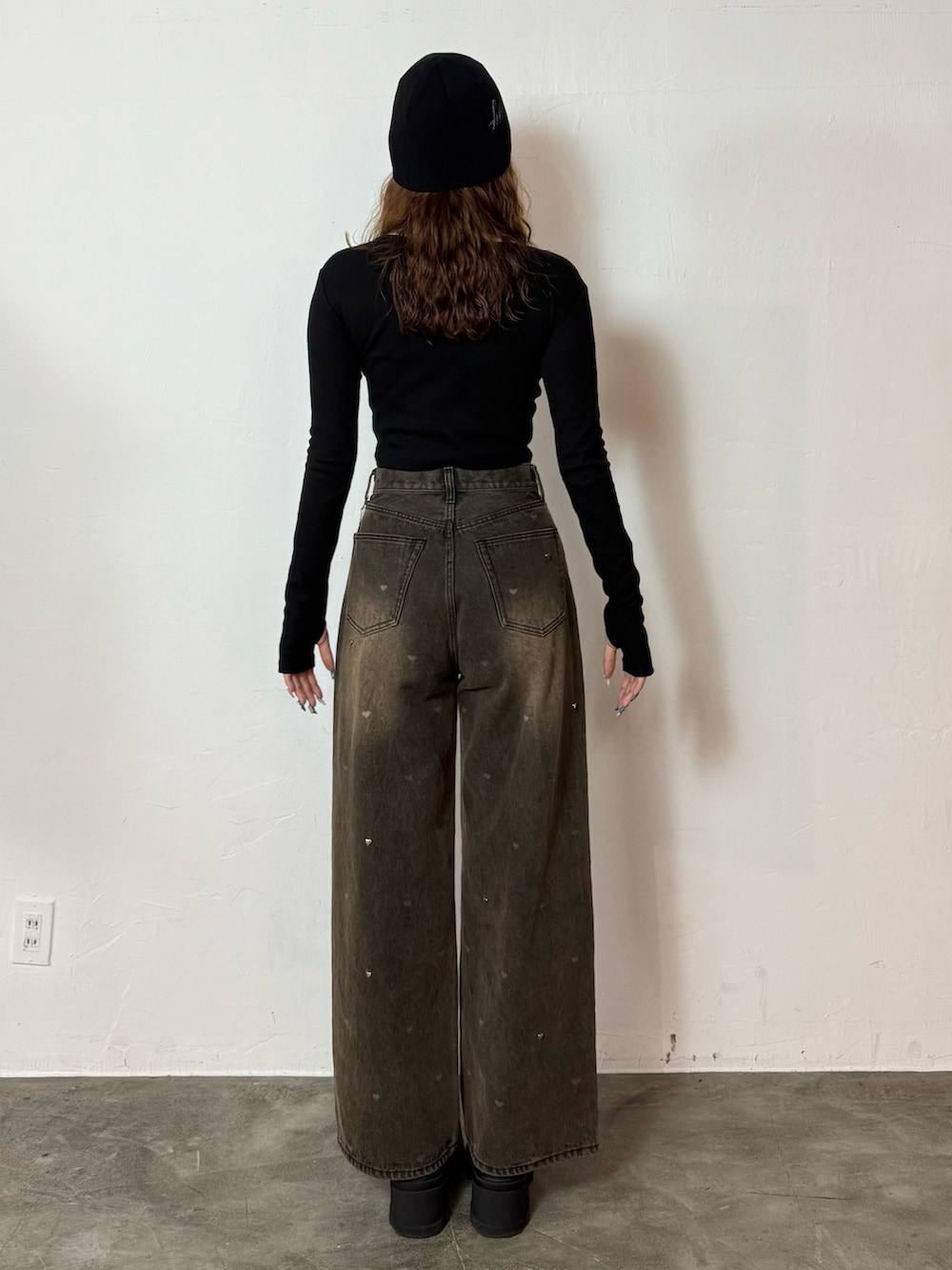 ブラック系のTシャツ/カットソー、ブラウン系のデニムパンツ、ブラック系のブーツを着用したレディースの秋コーディネートの3枚目の写真