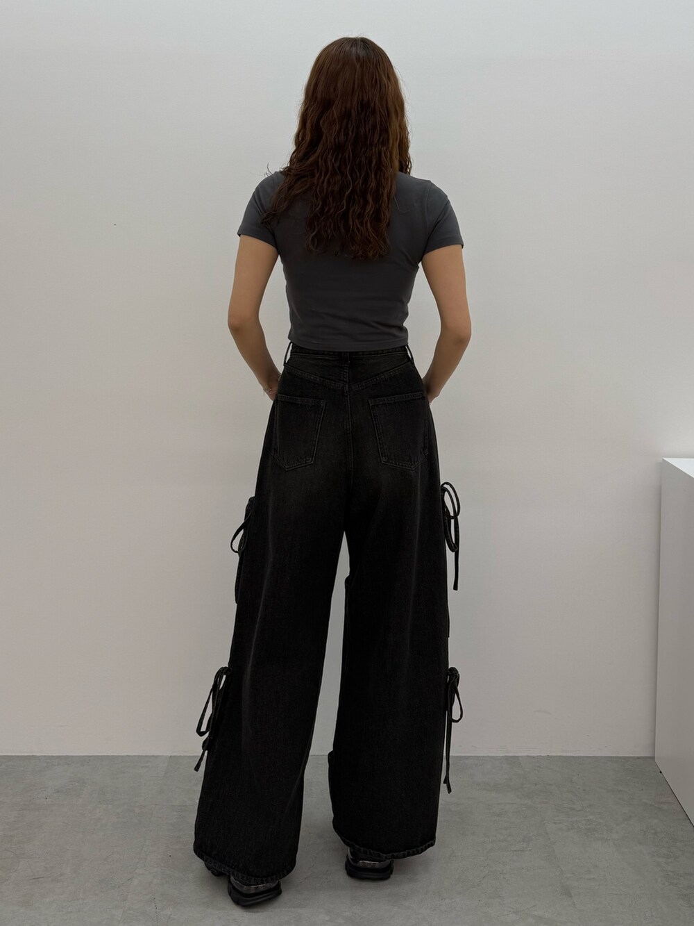 グレー系のTシャツ/カットソー、ブラック系のデニムパンツ、ブラック系のサンダルを着用したレディースの夏コーディネートの3枚目の写真