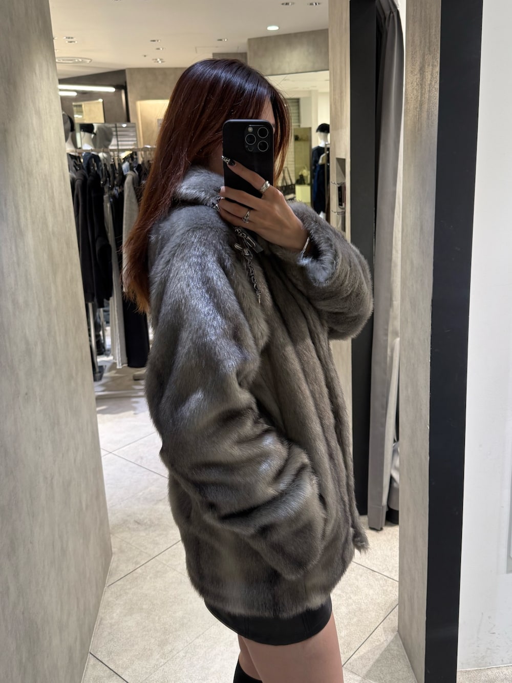 グレー系のその他アウター、ブラック系のスカート、ブラック系のブーツを着用したレディースの秋コーディネートの5枚目の写真