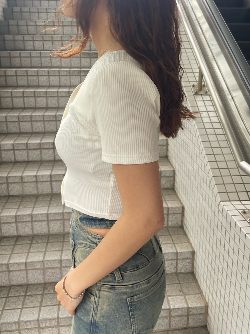 ホワイト系のTシャツ/カットソー、ブルー系のデニムパンツ、ブラック系のサンダルを着用したレディースの春コーディネートの5枚目の写真