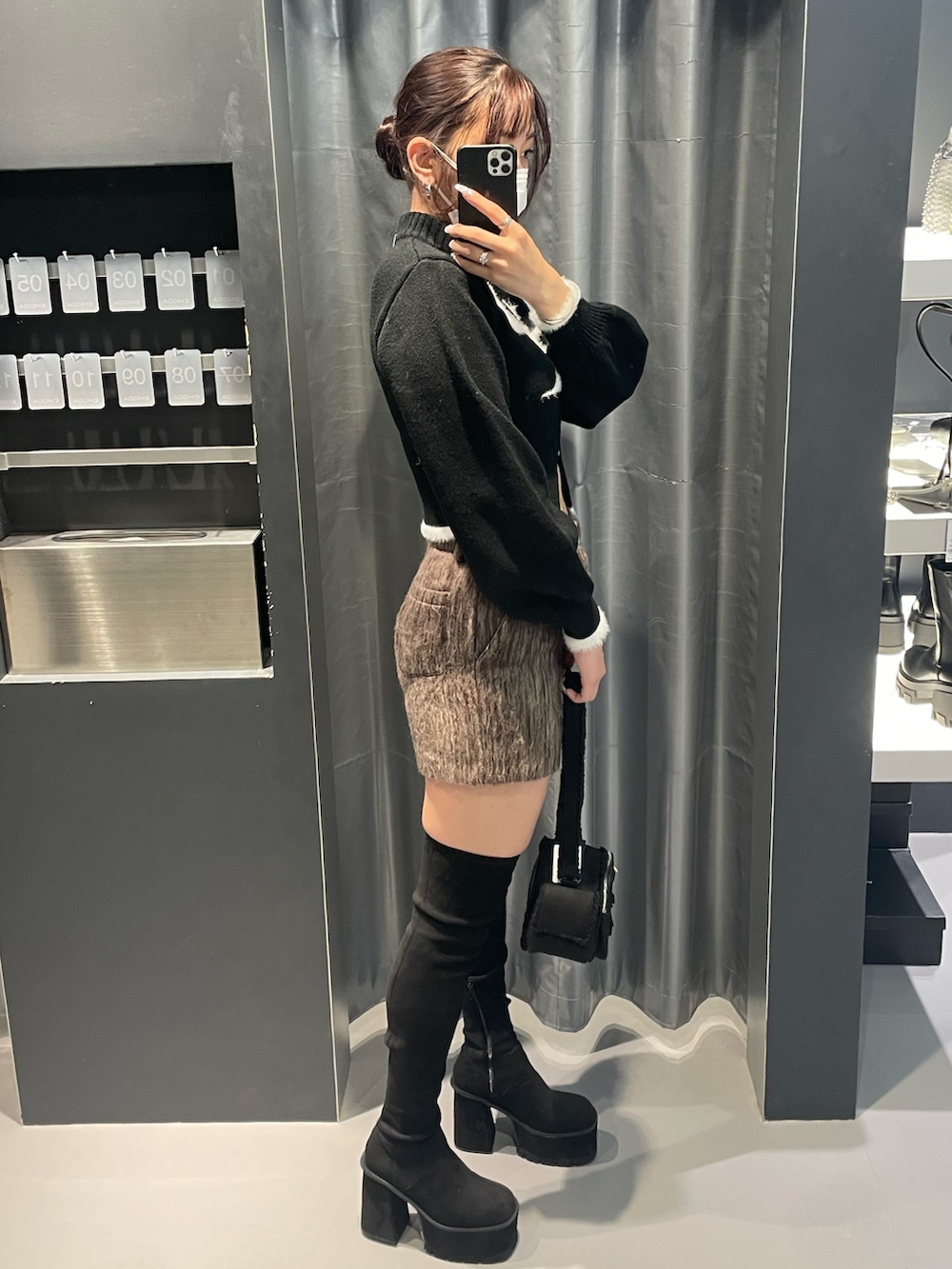 ブラック系のニット/セーター、ブラウン系のその他パンツ、ブラック系のショルダーバッグを着用したレディースの冬コーディネートの2枚目の写真