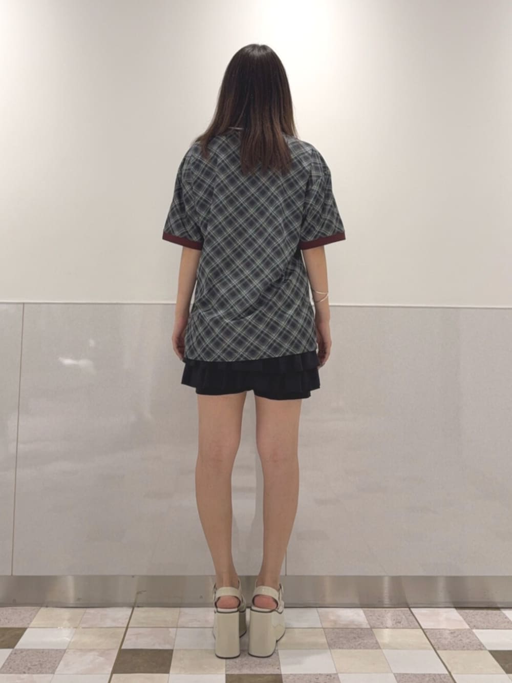 ブラック系のTシャツ/カットソー、ブラック系のスカート、ホワイト系のサンダルを着用したレディースの夏コーディネートの3枚目の写真