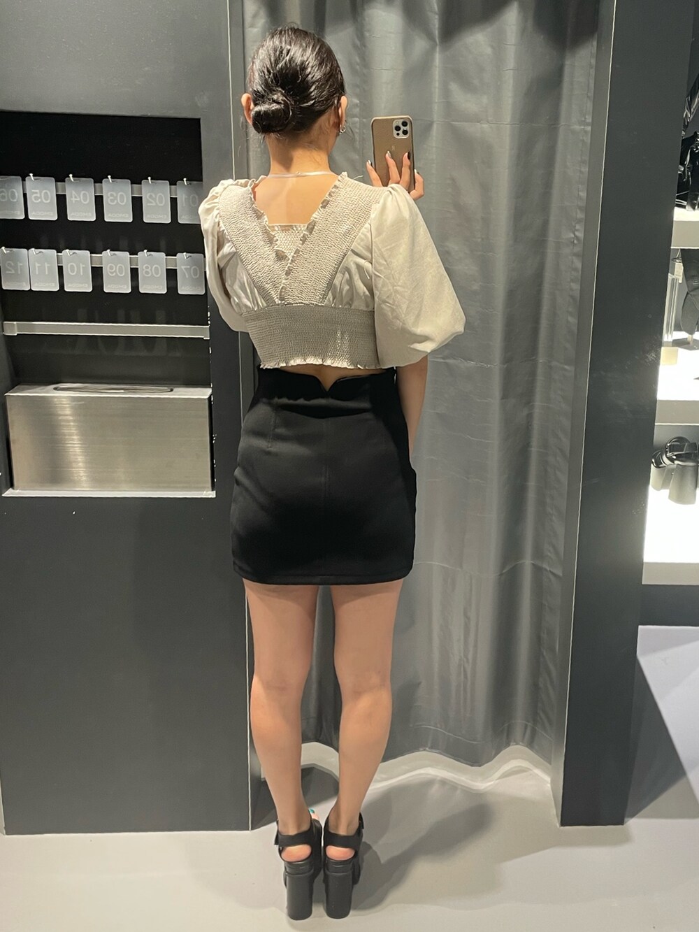 ベージュ系のTシャツ/カットソー、ブラック系のスカート、ブラック系のサンダルを着用したレディースの夏コーディネートの3枚目の写真