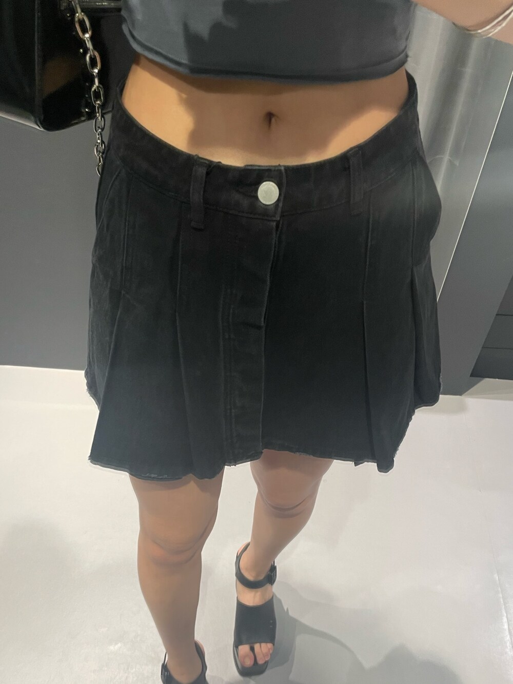 ホワイト系のTシャツ/カットソー、ブラック系のデニムスカート、ブラック系のショルダーバッグを着用したレディースの春コーディネートの7枚目の写真