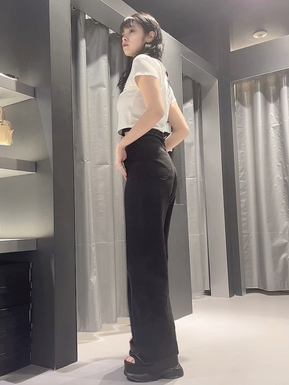 ホワイト系のTシャツ/カットソー、ブラック系のデニムパンツ、ブラック系のサンダルを着用したレディースの春コーディネートの2枚目の写真