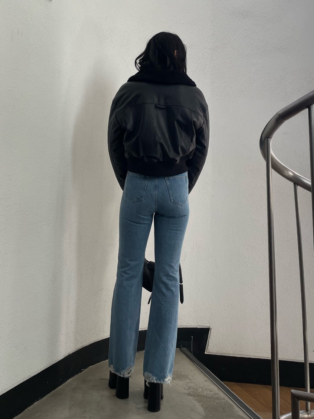 ブラック系のブルゾン、その他のニット/セーター、ブルー系のデニムパンツを着用したレディースの冬コーディネートの3枚目の写真