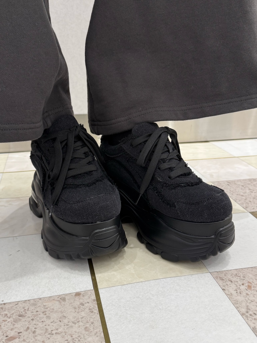 ブラック系のTシャツ/カットソー、グレー系のスウェットパンツ、ブラック系のスニーカーを着用したレディースの冬コーディネートの6枚目の写真