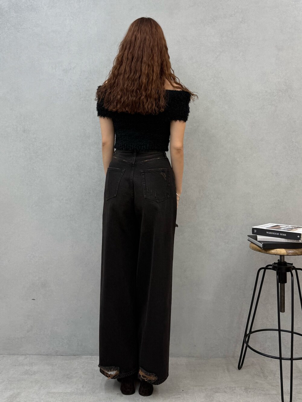 ブラック系のニット/セーター、ブラック系のデニムパンツ、ブラウン系のサンダルを着用したレディースの夏コーディネートの3枚目の写真